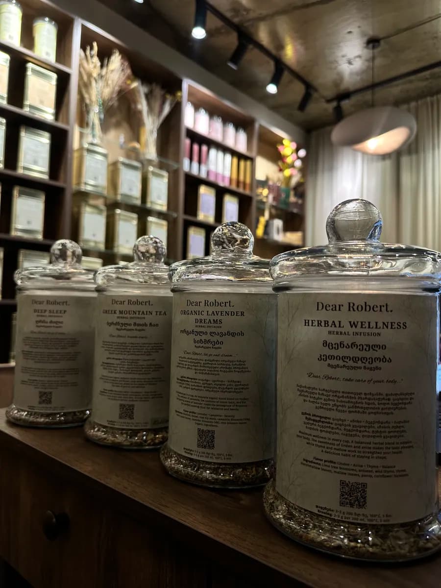 Glass jars with Dear Robert signature herbal teas on a wooden counter